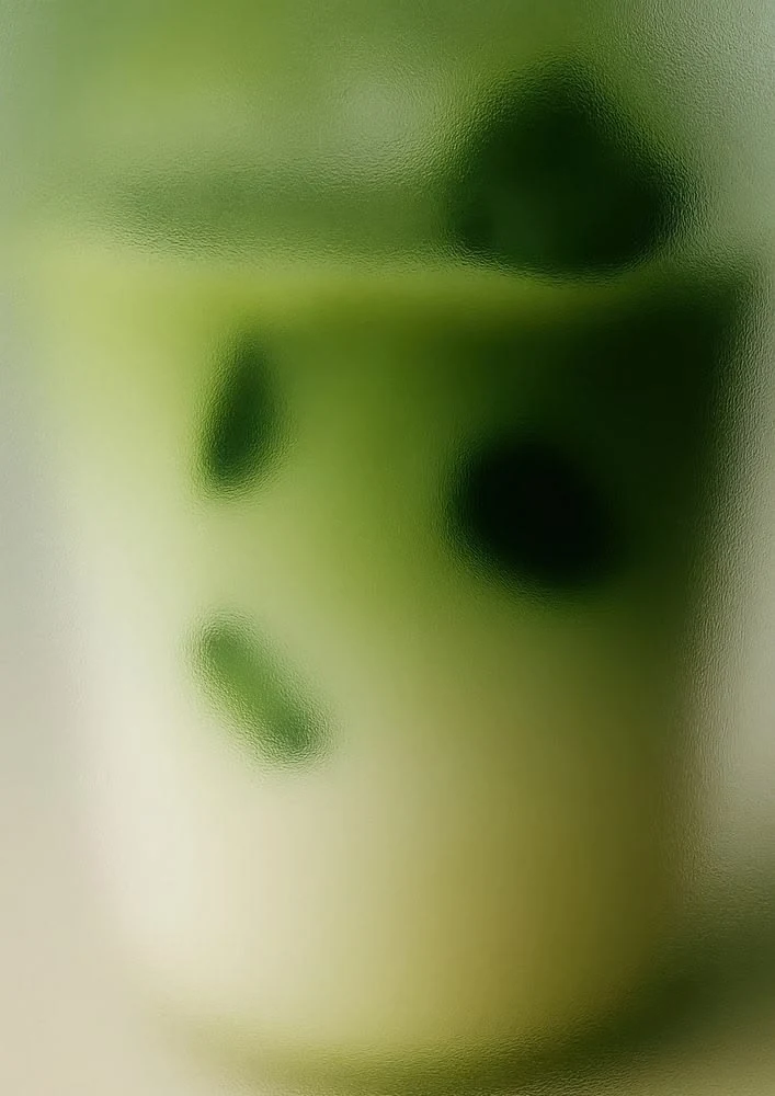 A soft-focus glass of iced matcha, used as the ground for the brewing method card