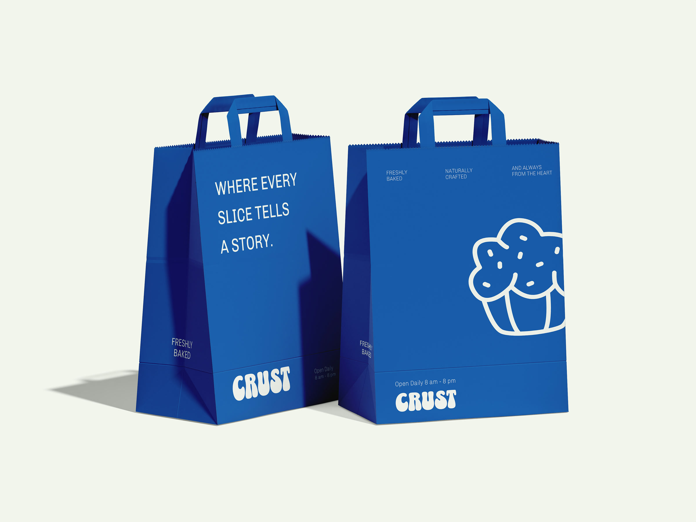 Two blue CRUST carry bags, one reading "where every slice tells a story", the other carrying a line-drawn cupcake