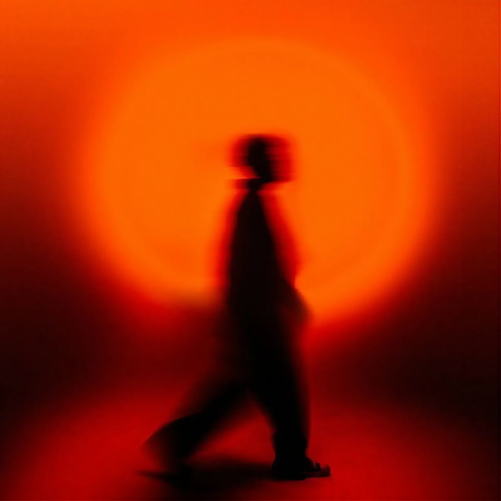 Motion blurred figure walking through a glowing burning orange field