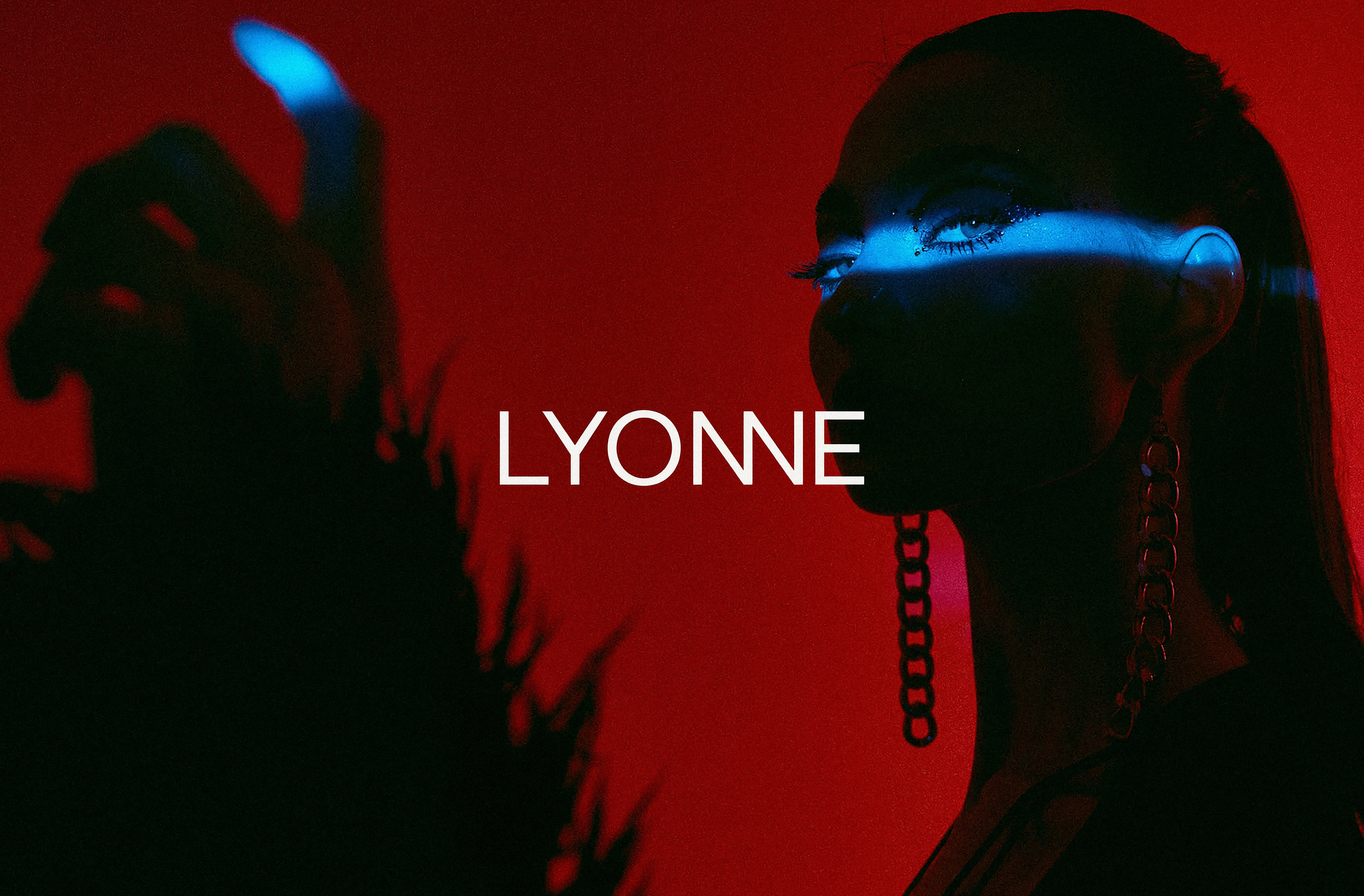Model in deep red gel light with a blue light bar across the eyes and chain earrings, the white Lyonne wordmark centered