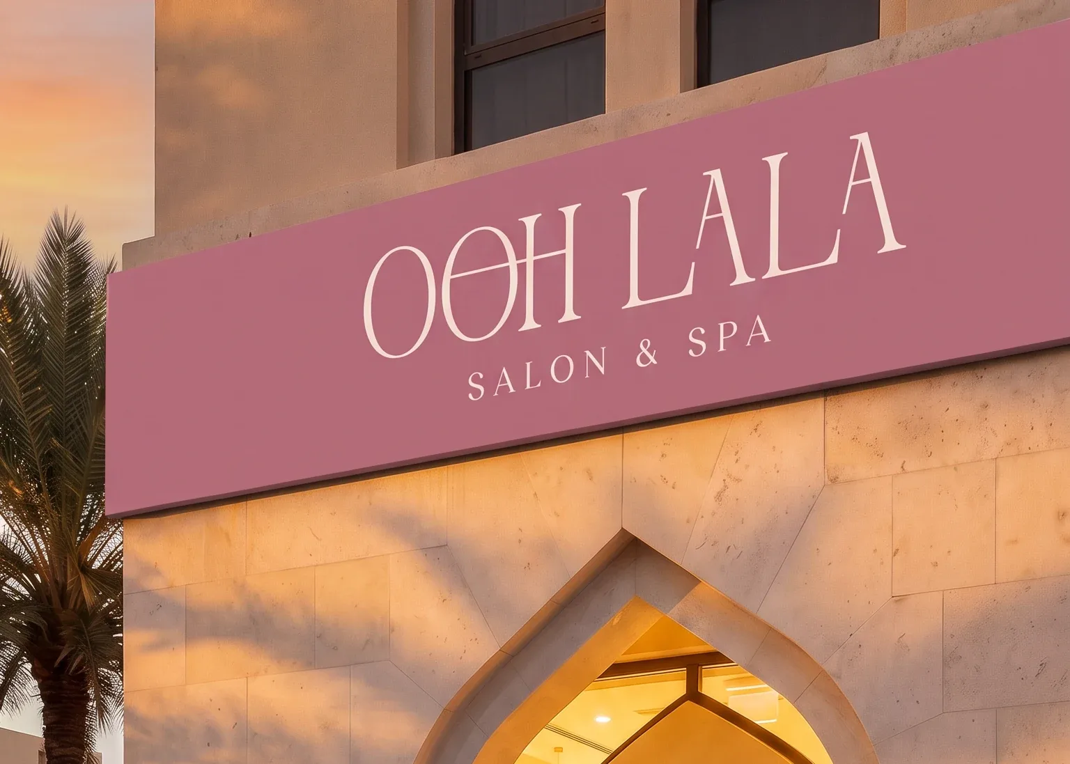 The same fascia in dusty rose at sunset, the identical camera position, the wordmark in cream above the same lit arch