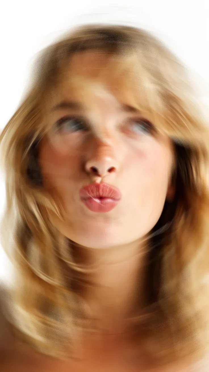 A face blurred by a swirl of motion, lips pursed, on white