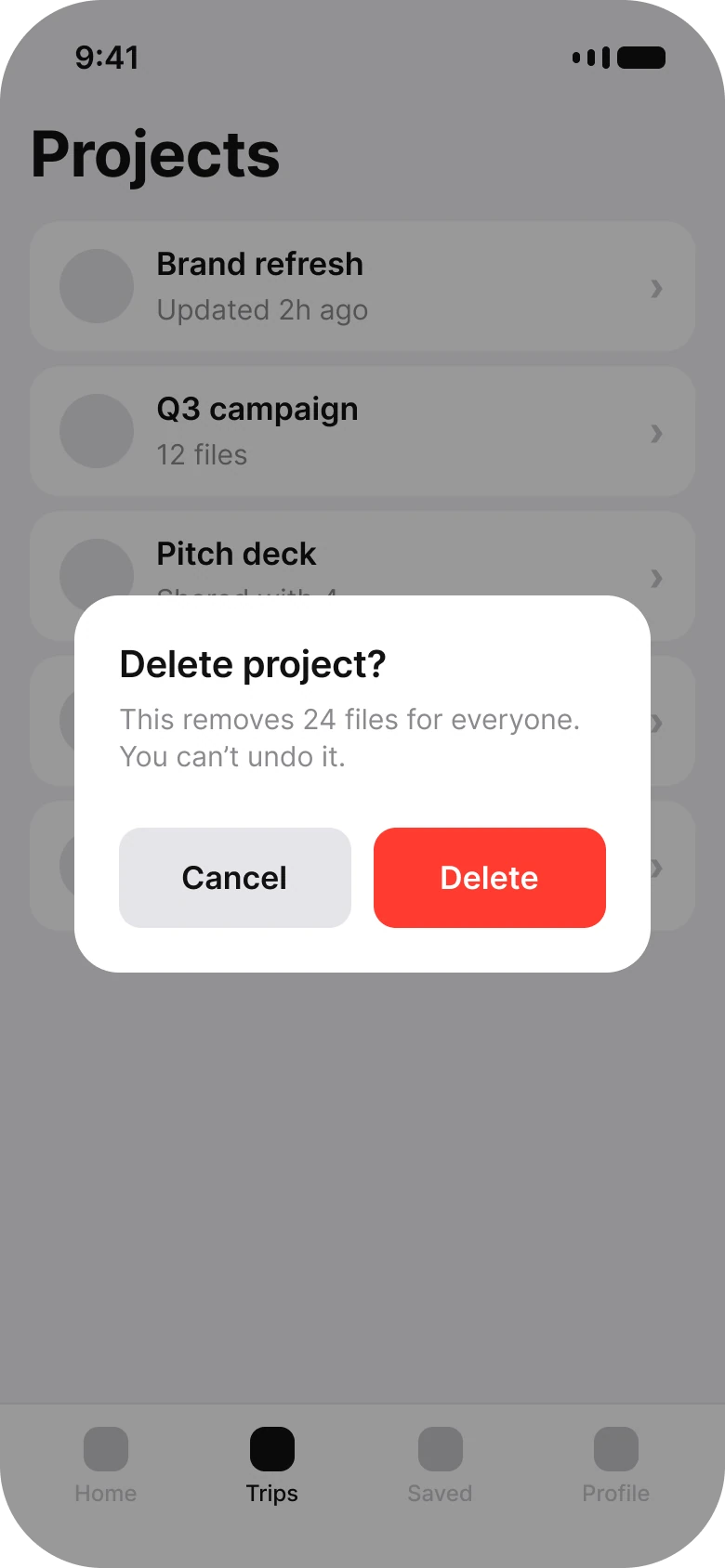 A Projects list dimmed behind a centered dialog: Delete project? This removes 24 files for everyone. You can't undo it. Cancel and a red Delete button